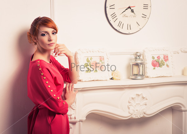Beautiful young fashionable woman posing in red dress. Looking at camera. Vogue style