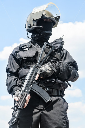 Spec ops soldier in black uniform and face mask with his rifle