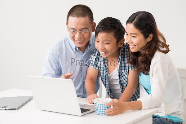 Asian family watching something funny on the laptop