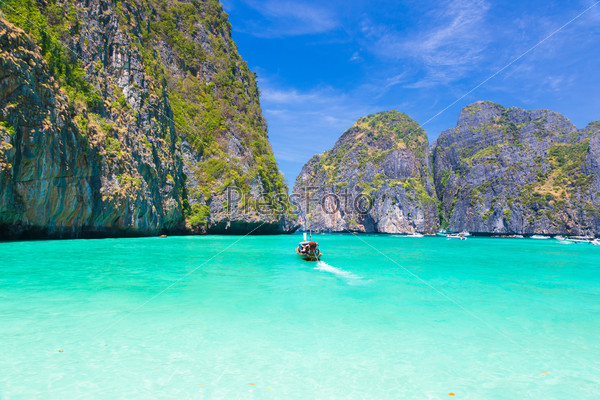 Traditional wooden boat in a picture perfect tropical Maya bay on Koh Phi Phi Le Island, Thailand, Asia.
