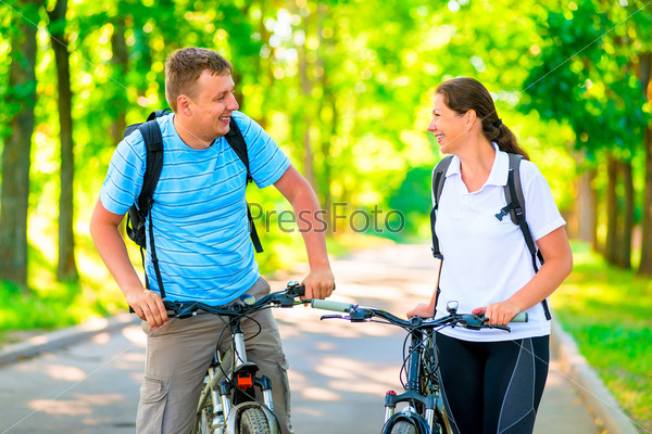 cheerful and happy cyclists in the morning park