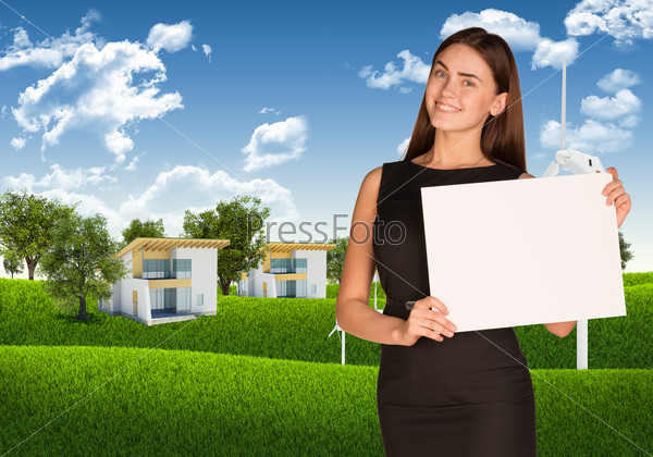 Businesswoman hold white paper. Blue sky, green grass and houses as backdrop, stock photo