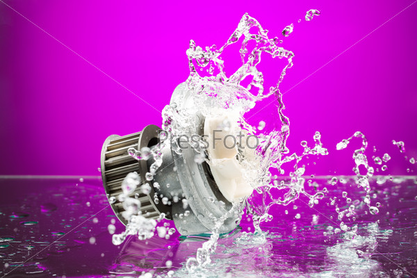 Auto parts, engine cooling pump in spurts of water on purple gradient background, stock photo