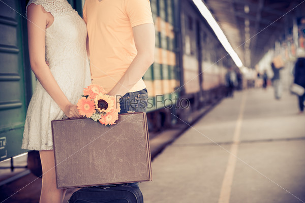Cropped image of girl giving farewell kiss to her boyfriend at the railway station