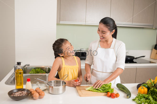 Vietnamese mother and daughter cooking together