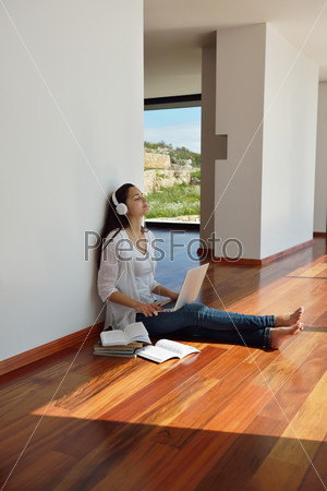 beautiful young woman relax and work on laptop computer while working on laptop computer and read book at home