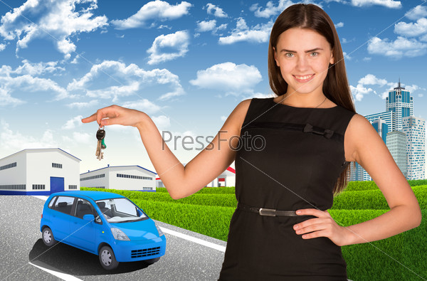 Woman with car key in hand. Small automobile on road
