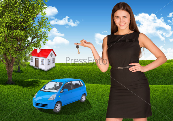 Woman with key in hand. Small automobile and house on grass