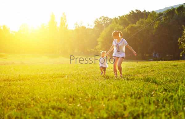 happy family on nature walks in the summer. mother and child run on field