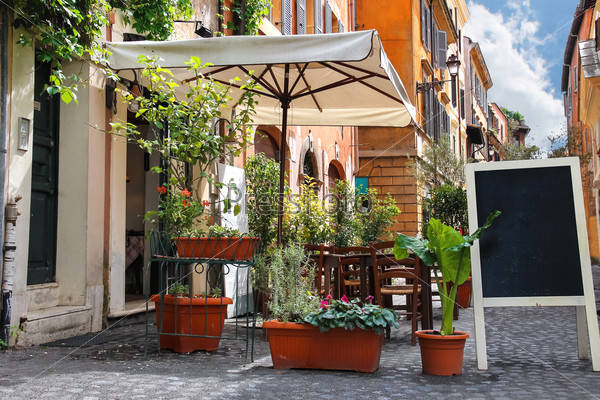 Tables outdoor cafe on a narrow street in Rome, Italy
