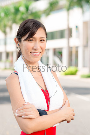 Portrait of confident female jogger with her arms crossed