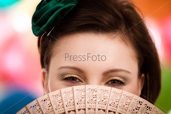 Lovely woman holding a fan. See more images from the same shoot.