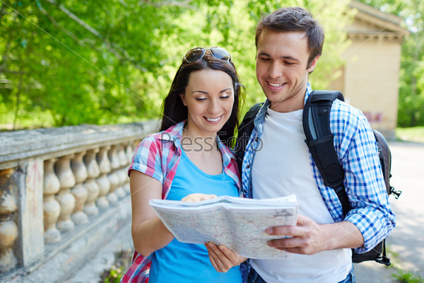 Two travel lovers studying map of ancient town