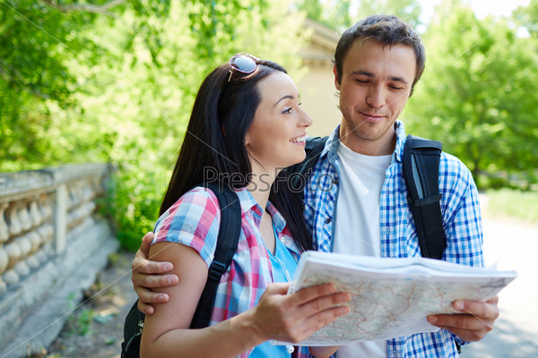 Modern travelers with map discussing where to go