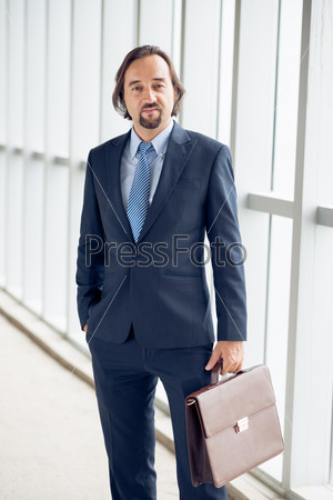 Portrait of confident Caucasian businessman with a briefcase