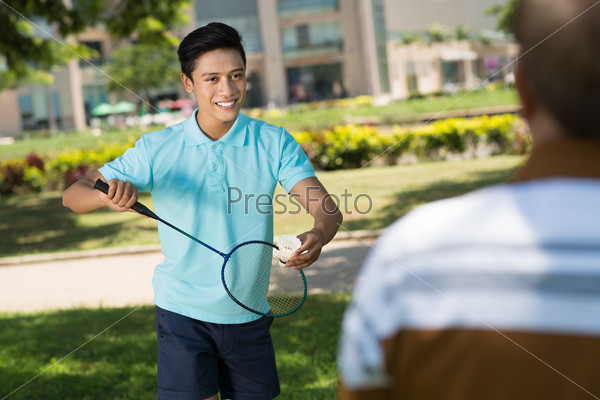 Vietnamese teenager playing badminton in the park