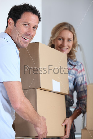 Couple moving a pile of large cardboard boxes