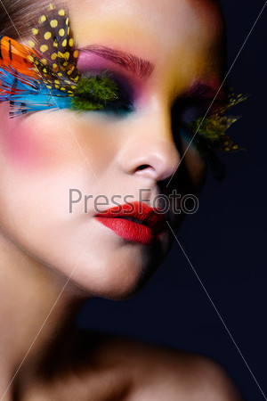 Woman with bright stylish make-up, green hair and false fashion feather eyelashes