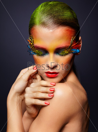 Woman with bright stylish make-up, green hair,  false fashion feather eyelashes and red manicure