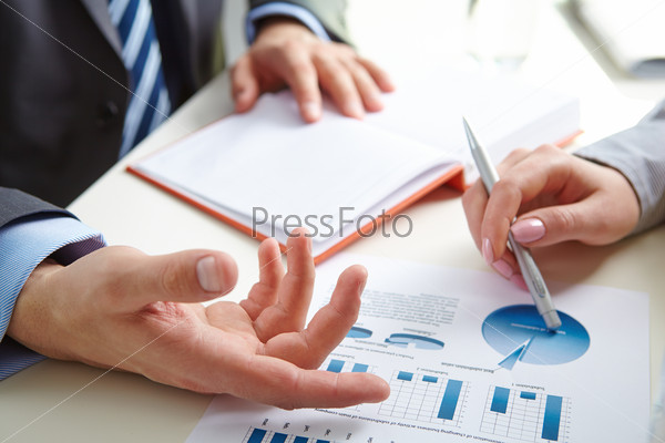 Male hand pointing at paper containing data about economic situation