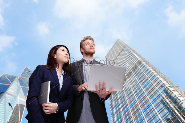 Business meeting - two managers discussing on tablet computer with city background