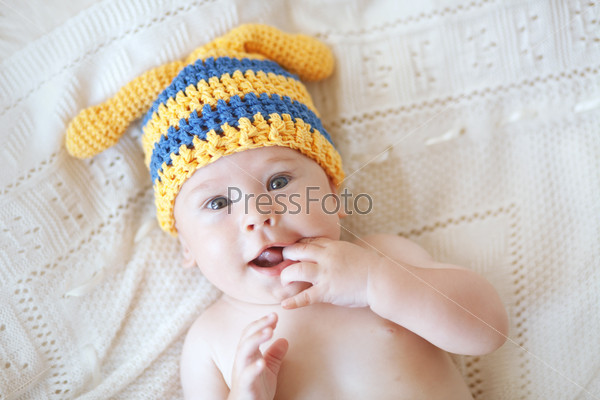 Portrait of a cute 4 months baby wearing crochet knit hat, top view point