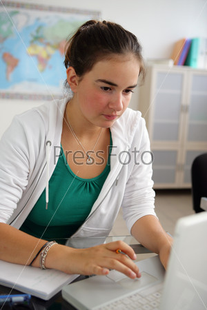 Portrait of a young girl in front of a laptop computer in a classroom