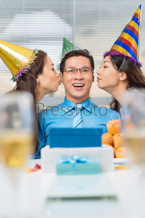 Pretty manager kissing birthday man on both cheeks