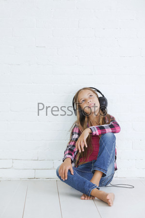 8-9 years old stylish teen girl with black headphones posing on white background