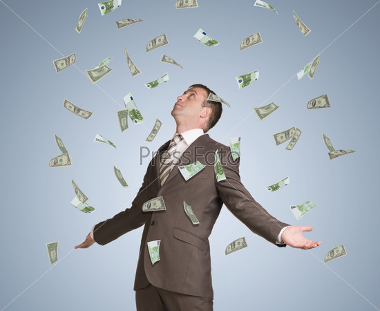 Businessman in suit spread his arms and looking up. Money fall from above, stock photo