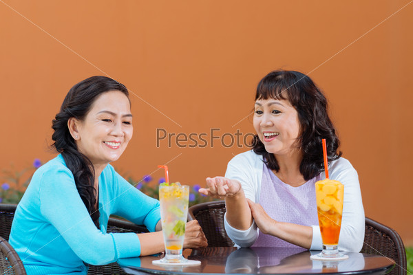 Vietnamese mature women chatting and drinking cocktails in the cafe