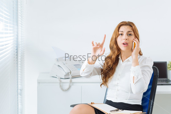 Businesswoman explaining things on cell phone and looking at camera
