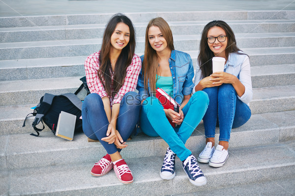 Portrait of three teenage girls sitting on steps