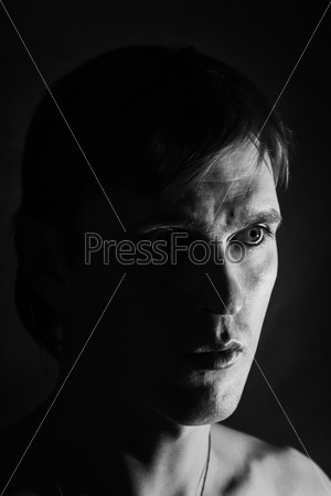Black and white portrait of a young man on a black background