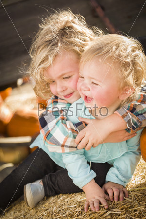 Little Boy Playing with His Baby Sister at Pumpkin Patch