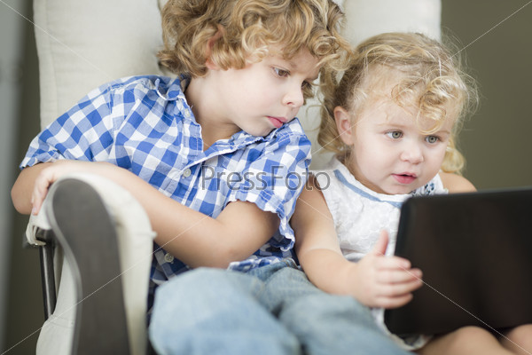 Adorable Young Brother and Sister Using Their Computer Laptop Together.