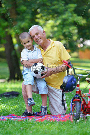 Счастливый дедушка с внуком в парке