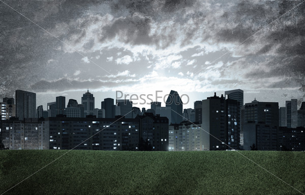 Evening city. Buildings and green grass field. Grunge style, stock photo