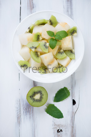 Salad with melon, kiwi and mint, view from above