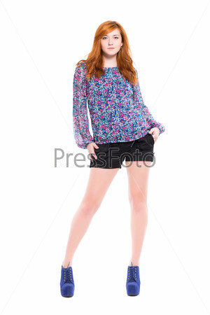 Pretty young woman posing in black shorts and flowery blouse. Isolated on white