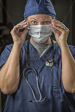Concerned Female Doctor or Nurse Putting on Protective Facial Wear.
