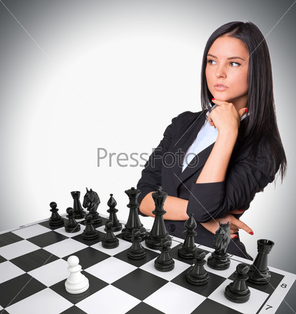 Lost in thought businesswoman up. Chessboard with chess. Gray background. Business concept