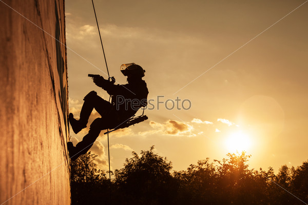 Silhouette of police officer during rope exercises with weapons