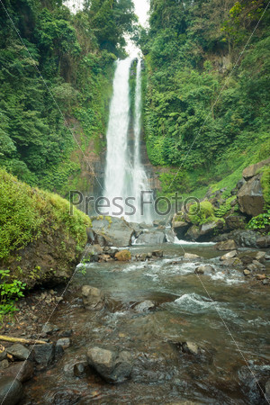 Beautiful tall waterfall deep in Bali jungle