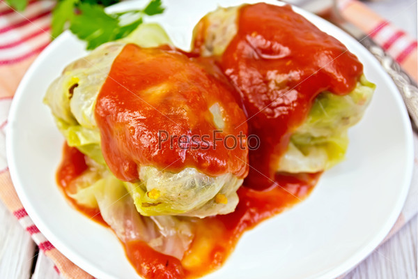 Cabbage stuffed and tomato sauce in plate on board
