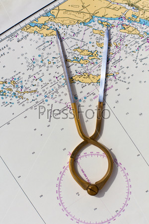 Pair of compasses for navigation on a sea map. Vertical shot, stock photo