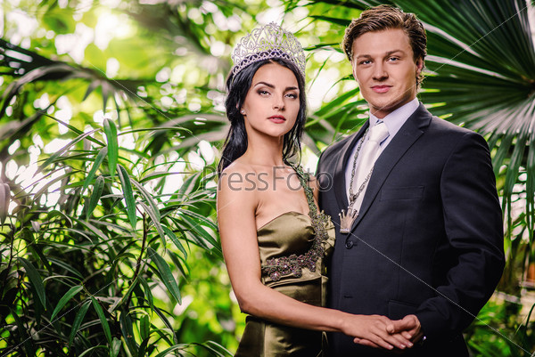 Gorgeous lady in long evening dress and with tiara on a head and handsome man in classic suit