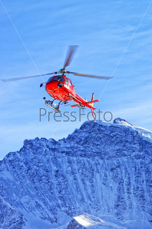 Red helicopte rat swiss alps near Jungfrau mountain