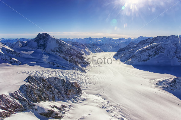 Swiss Aletch glacier helicopter view in winter under bright sunshine