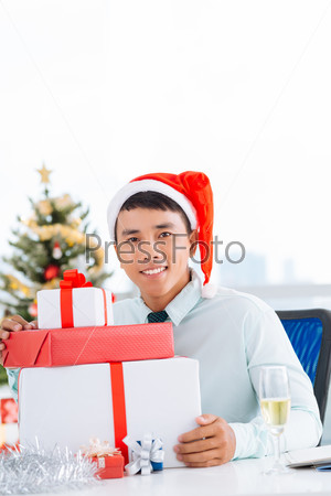 Handsome manager with Christmas gifts at his workplace